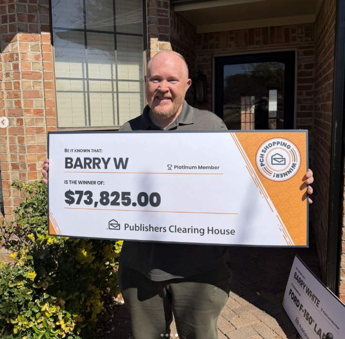 Barry holding his big check