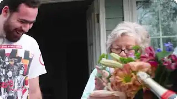 A winner receives flowers and champagne